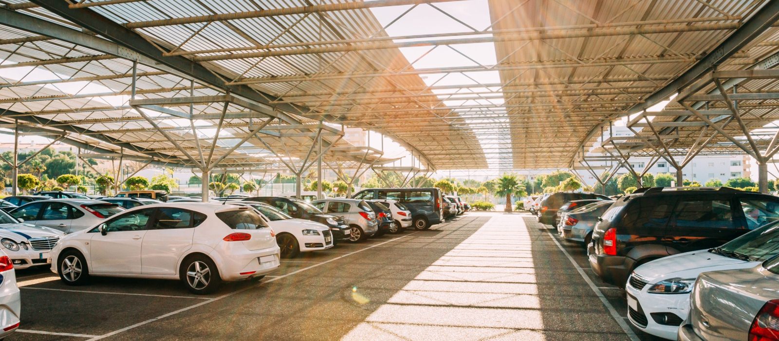 Cars on a covered parking lot in sunny summer day